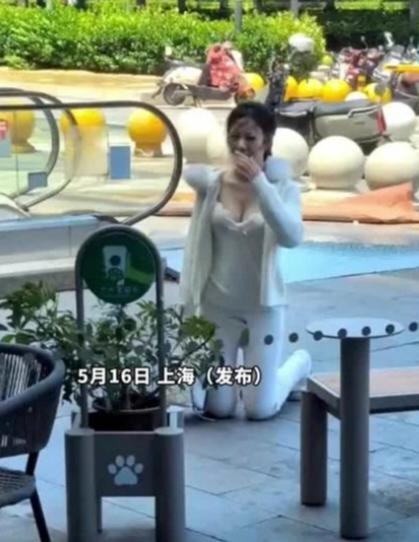 5月16日上海街头：女子当街跪地，男子全程低头玩手机。这事发生在白天，周围人来