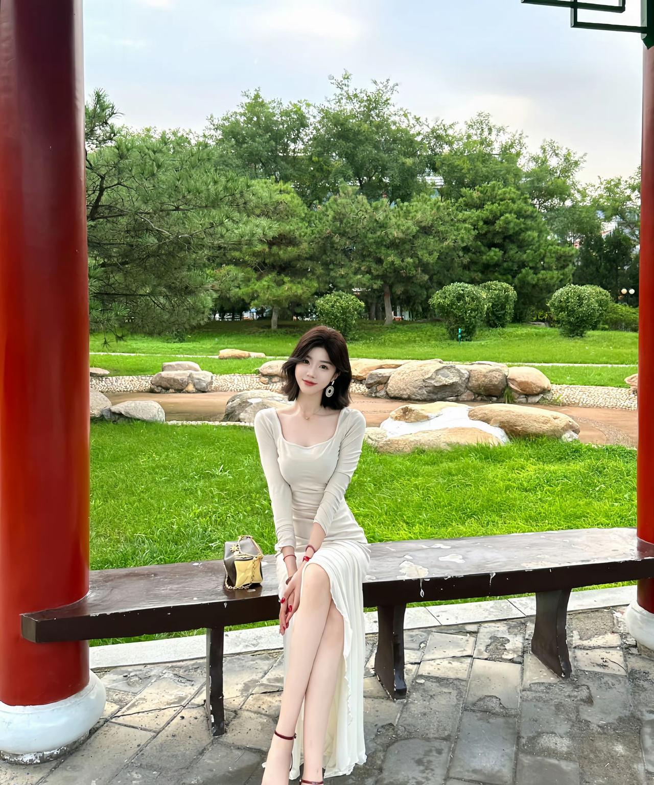 夏日公园长椅上，优雅女子静坐，绿意盎然，享受宁静时光。