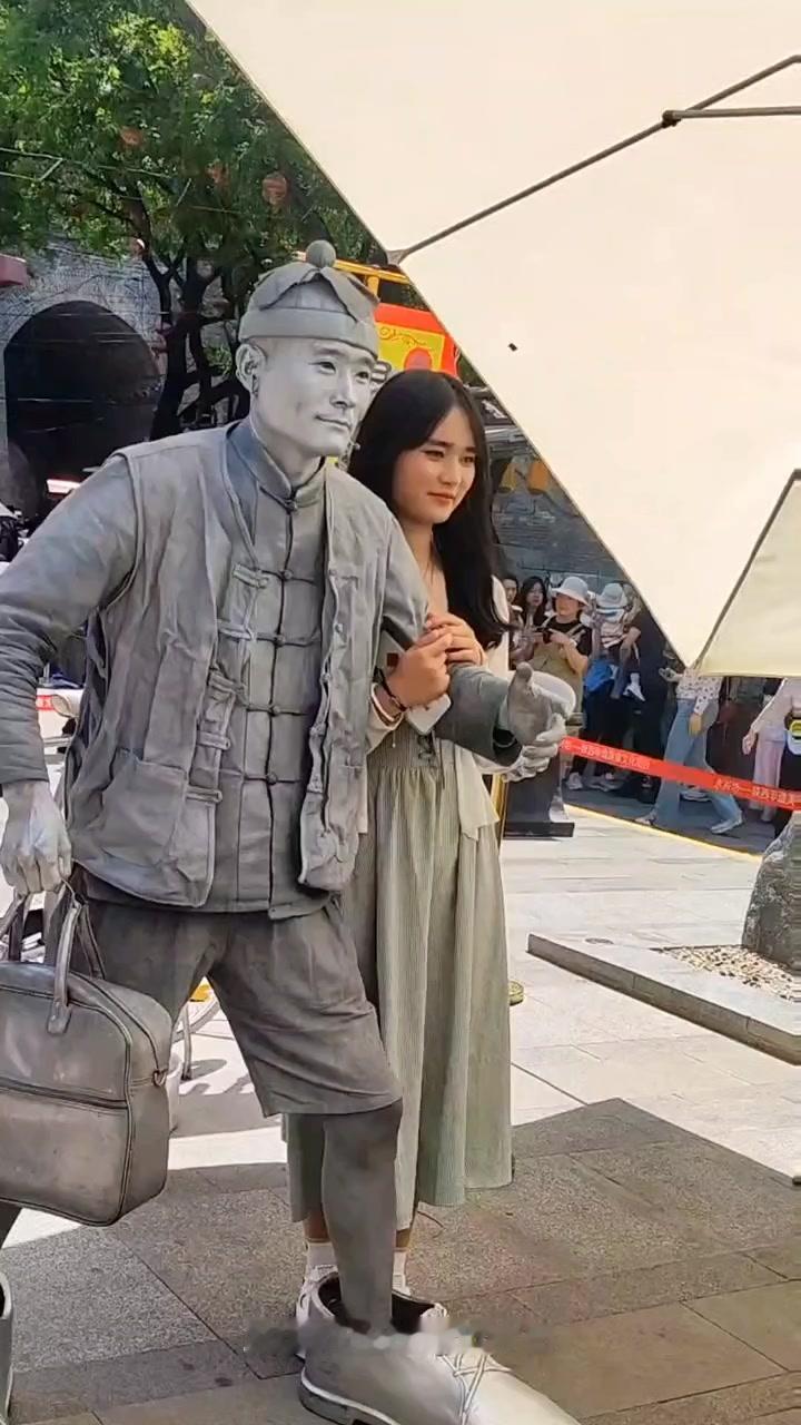 在西安街头，藏着许多不期而遇的温柔。我偶然遇见了一位银人雕塑，他安静地伫立在街边