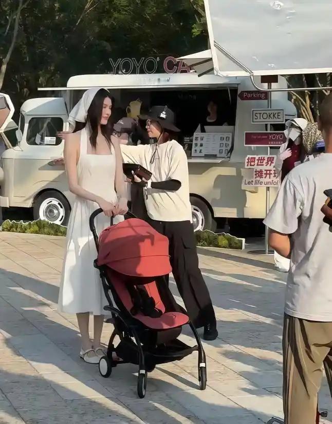 超模何穗在阿那亚拍婴儿车广告，白裙配白头巾仙气十足，生完孩子后事业反而更火了