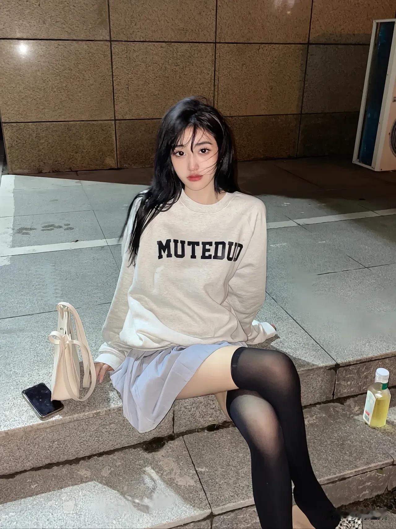 夜晚的街头，黑丝袜与米色卫衣的碰撞，都市女孩的时尚穿搭