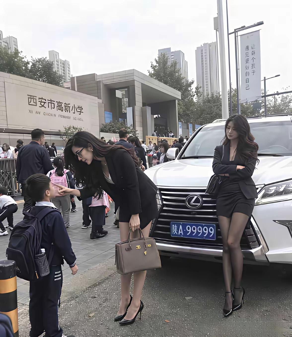 校门口的一幕，引得路人纷纷侧目。西安高新小学门口，豪车停在路边，两位气质出