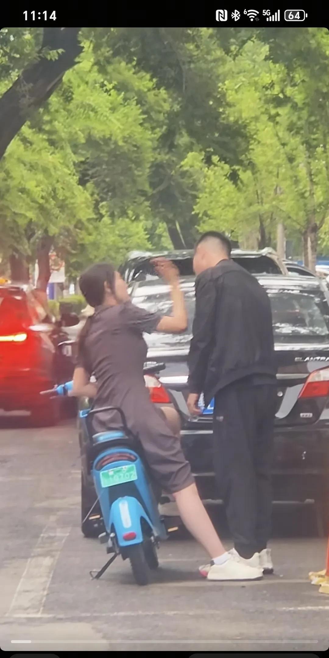 在街上看到这样一幕：一名女子坐在电动车上，朝着站在她身旁的男子左边脸扇了十二巴掌