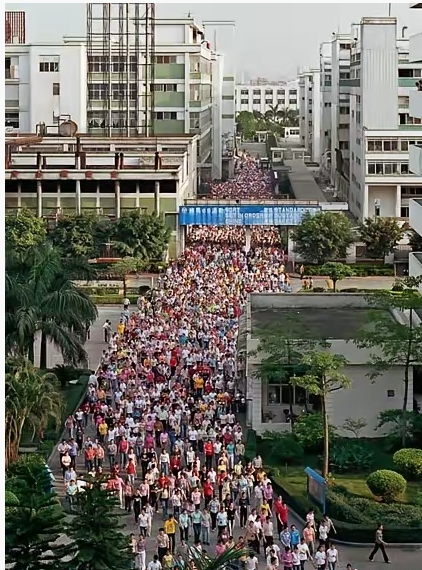 2004年，广东东莞高埗镇裕元鞋厂工人换班时的情景