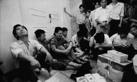 1999年8月，东北某机械厂的下岗工人坐在工厂门口，有的失声痛哭，有的仰头悲伤，