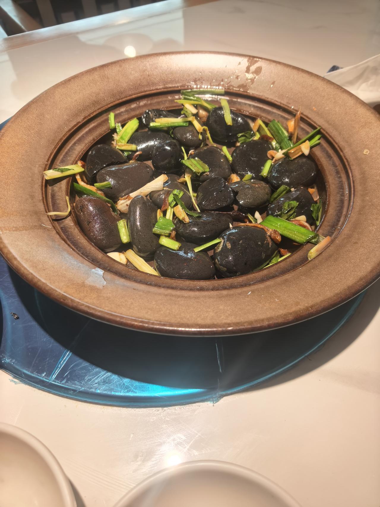 今天去饭店吃饭，看见对面桌上剩了一盘子菜，像是松花蛋或者是肉之类的东西，黑乎乎的