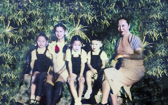 下图是徐志摩前妻张幼仪与孙子们的合影，这张照片中的张幼仪被子孙环绕着，脸上却并没