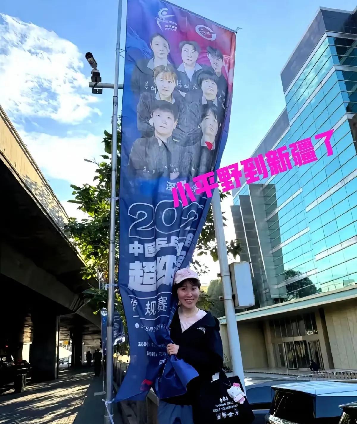平野美宇这刚下飞机，就直接奔新疆去了！她站在深大的条幅跟前，比着耶自拍，笑起来那