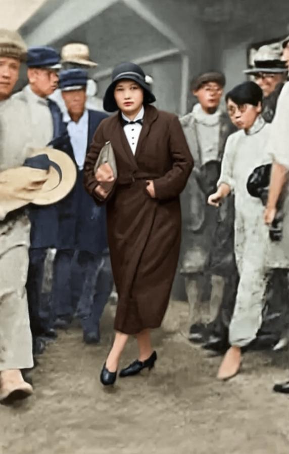 1931年8月13日，上海的码头人头攒动。一位身着风衣、头戴钟形帽的女士，在人群