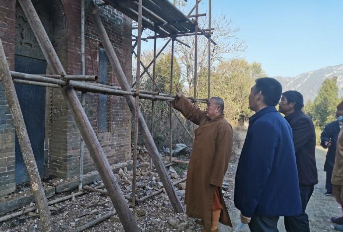 这是少林寺前方丈释永信指导建筑工人修缮少林寺颓败的房子。这些建筑工人要认真听取释