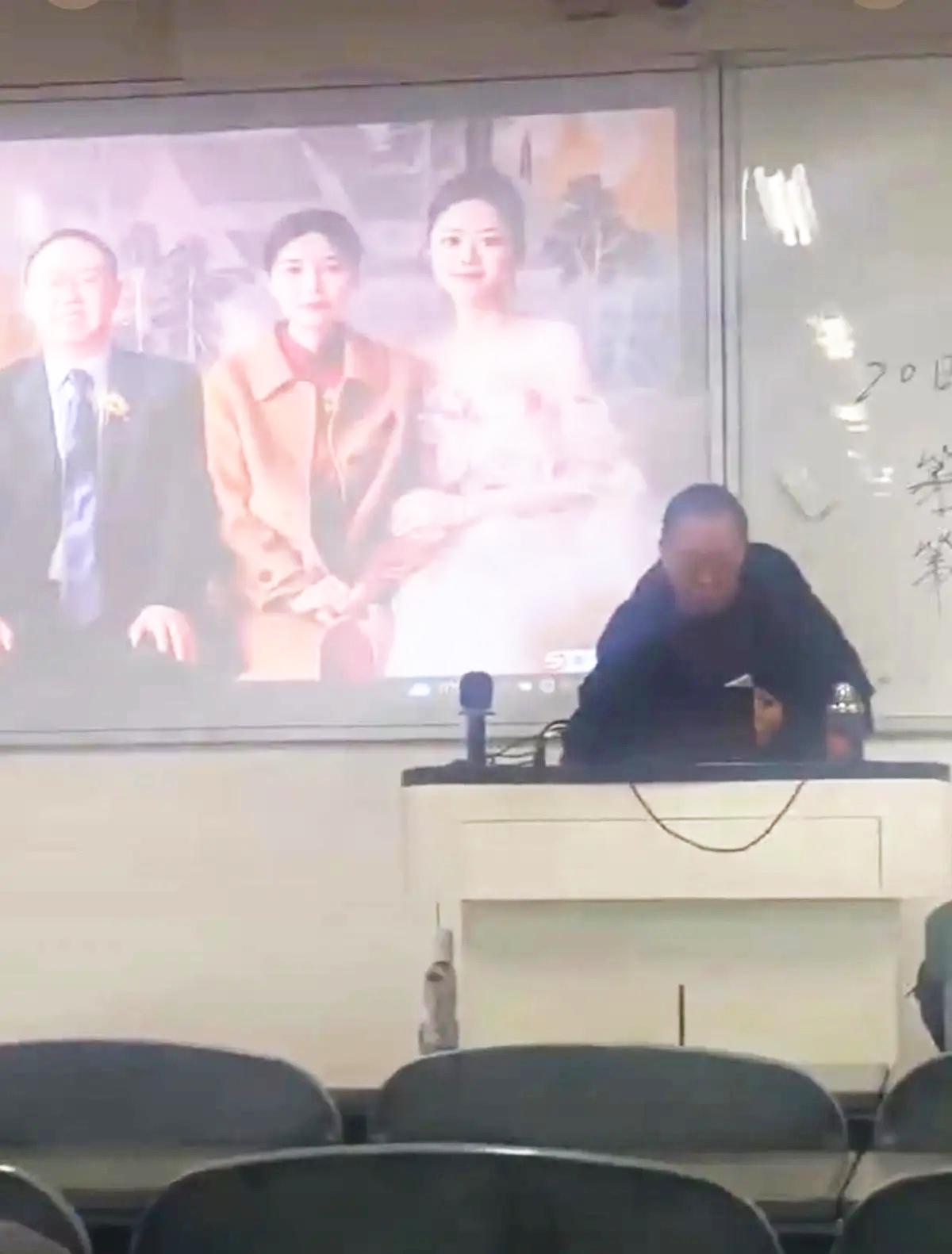 一个大学老师，正上着课，投影屏幕上的PPT突然跳了一下。底下几百个学生，手机都