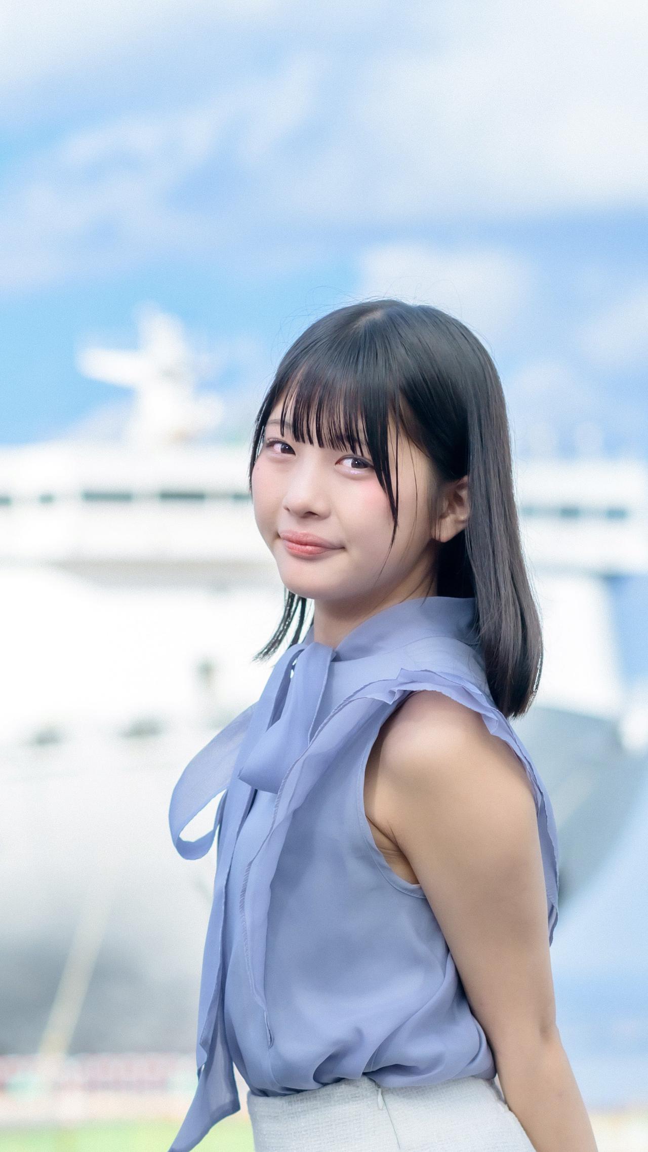 海边少女，微笑如阳光，轻盈的蓝裙随风飘扬。