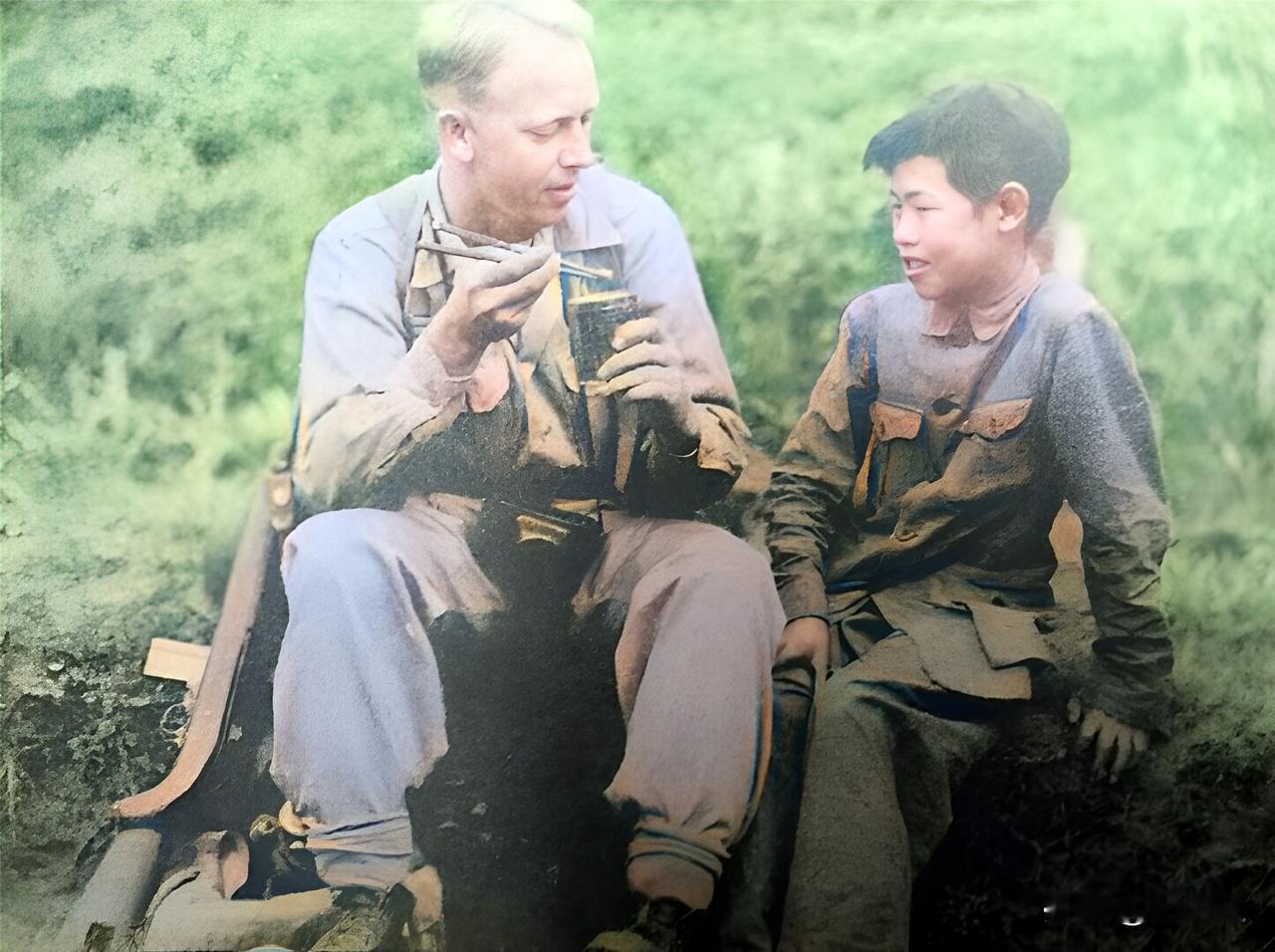 1944年5月，中缅印战场上，一名中国小男孩教一名美国大兵使用筷子吃罐头。可见，