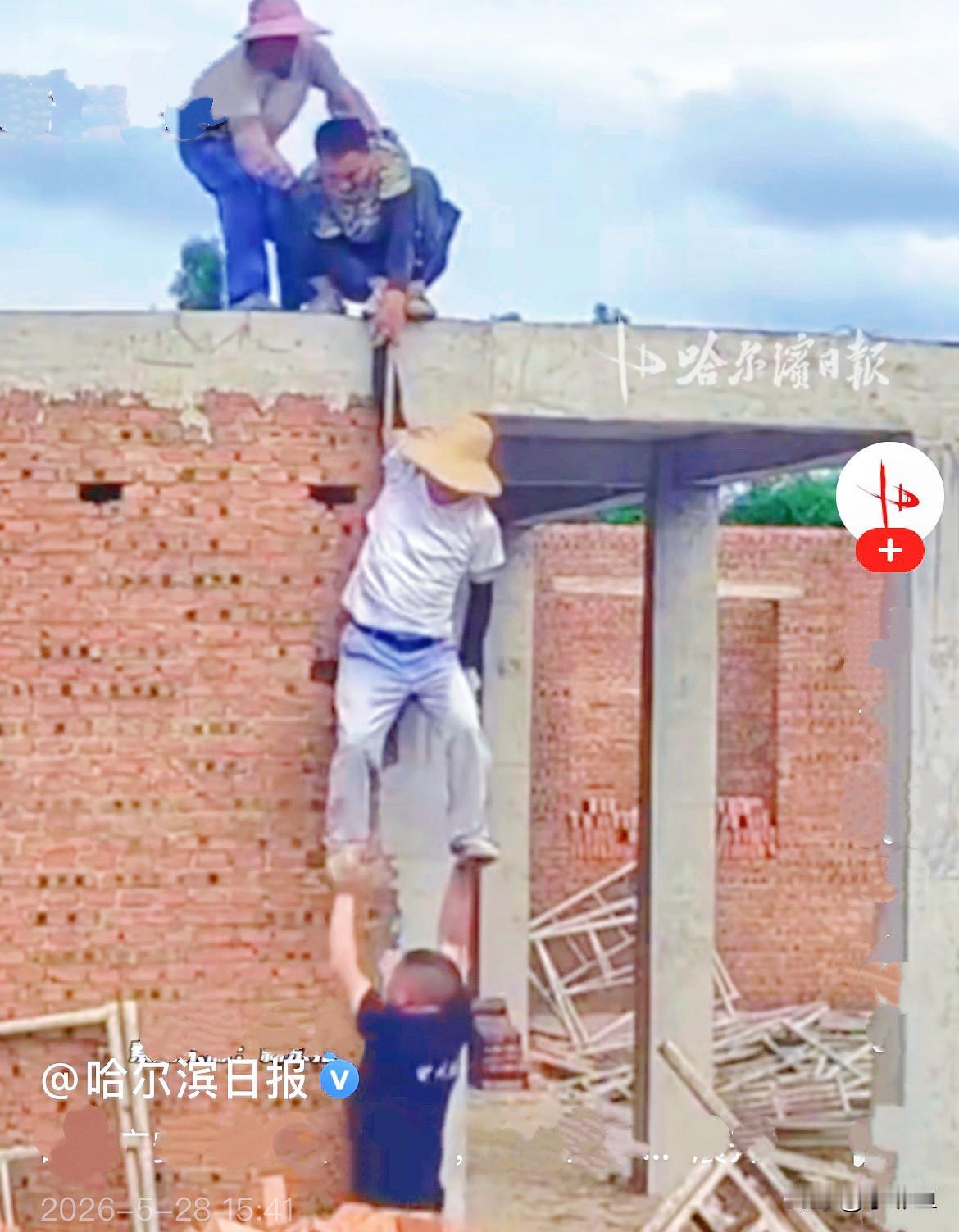 近日，四川广安一处工地的屋顶上，两名工人正在屋顶高空调试吊机设备，谁也没料到意外