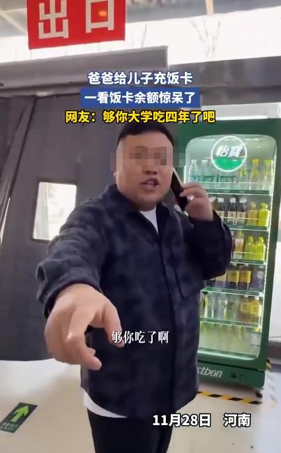 “财大气粗”！餐厅里，一名男子给上学的儿子充饭卡，然后将饭卡交给儿子，儿子问父亲