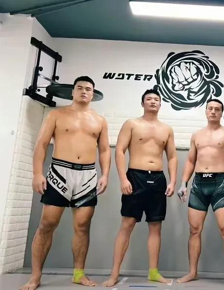 看看张名扬体型谁与争锋，他身边两个也是属于强壮的壮汉，但和张名扬站在一起，小巫见