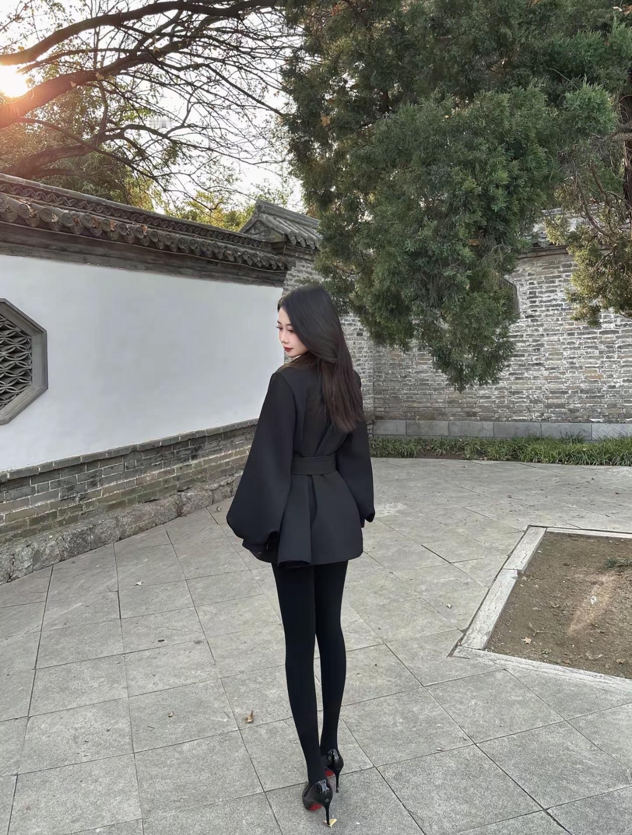 优雅黑衣女子漫步古风庭院，秋日暖阳洒落，岁月静好。