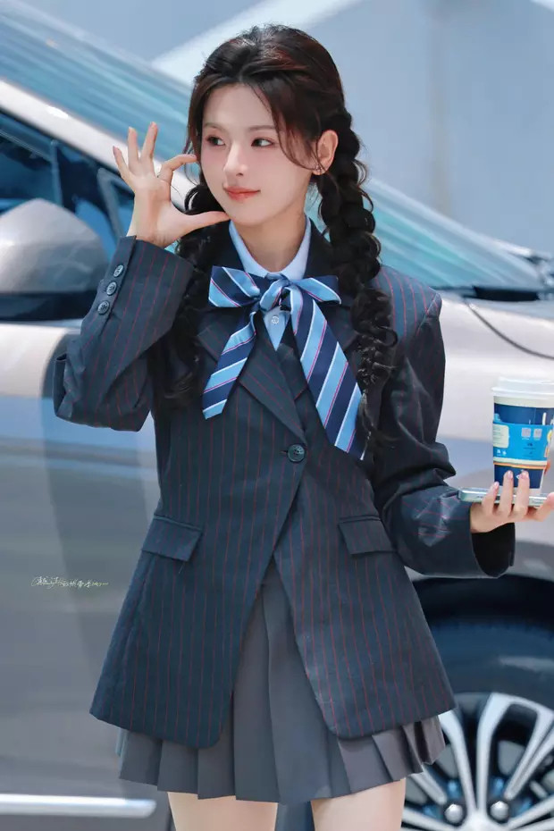 杨超越穿制服短裙现身综艺录制，照片里的她扎着双麻花辫，身材窈窕，甜美比心。​​