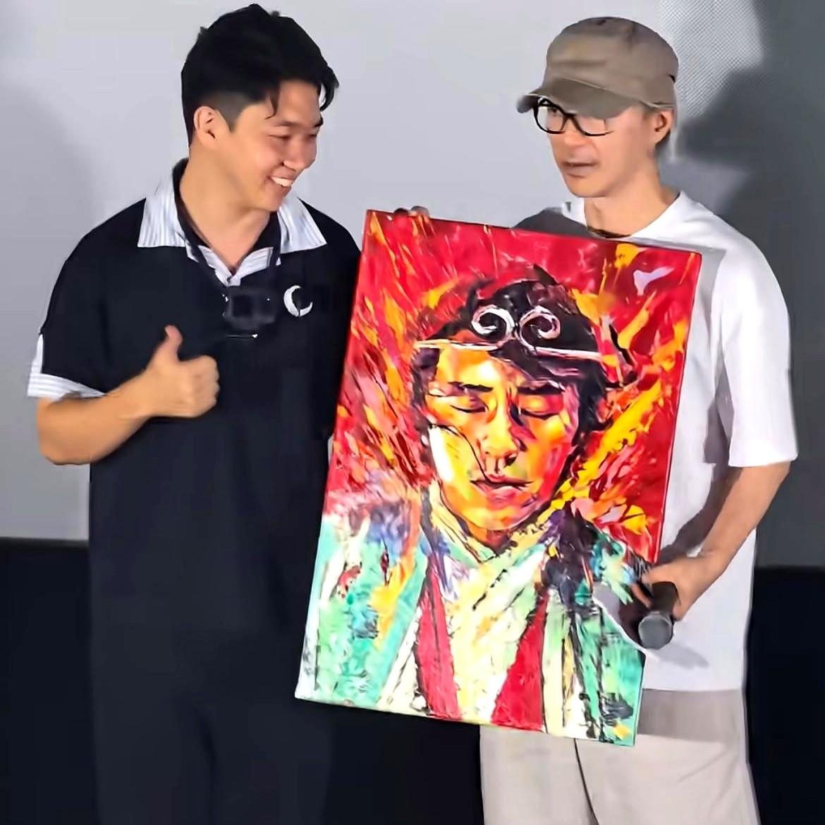 星爷又被宠成小孩了。成都路演上粉丝送出一幅至尊宝油画，直接扑上去死死搂住他不放