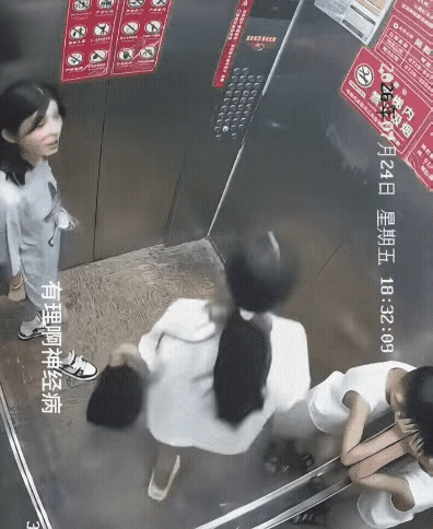 女孩坐电梯下楼，中途有一个男孩上了电梯，并用脚挡住电梯门，等妈妈上电梯，可妈妈太