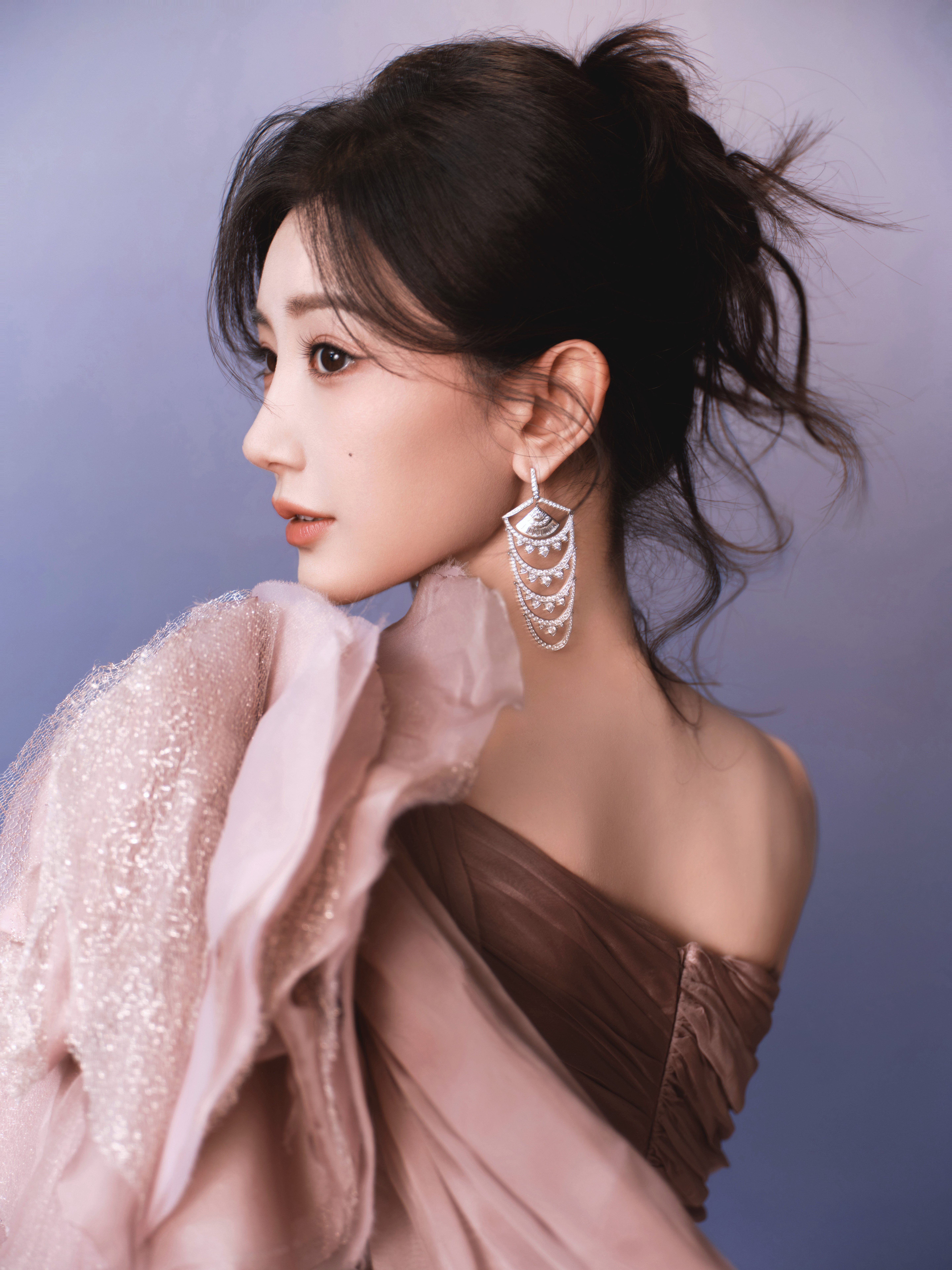 毛晓彤烟粉纱裙裁作流云，斜肩的褶皱揉着温柔的锋芒，曳地裙摆漫开时，似将暮色里的