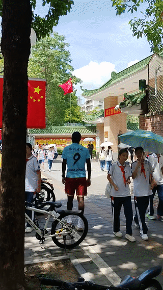 这个老黑在学校门口干嘛呢？他这是在接孩子放学？还是在等老婆或者是女朋友下班啊