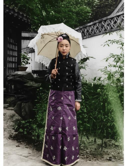 这张照片是晚清时期一位满族贵族女子的珍贵留影，女子站姿优雅，直视镜头，显然是在精