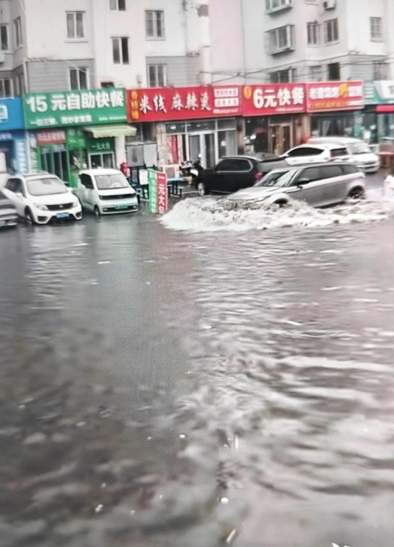 今天的这场大雨导致即墨区通济新区西元庄社区西元四路积水严重，水位都快没过小轿车车