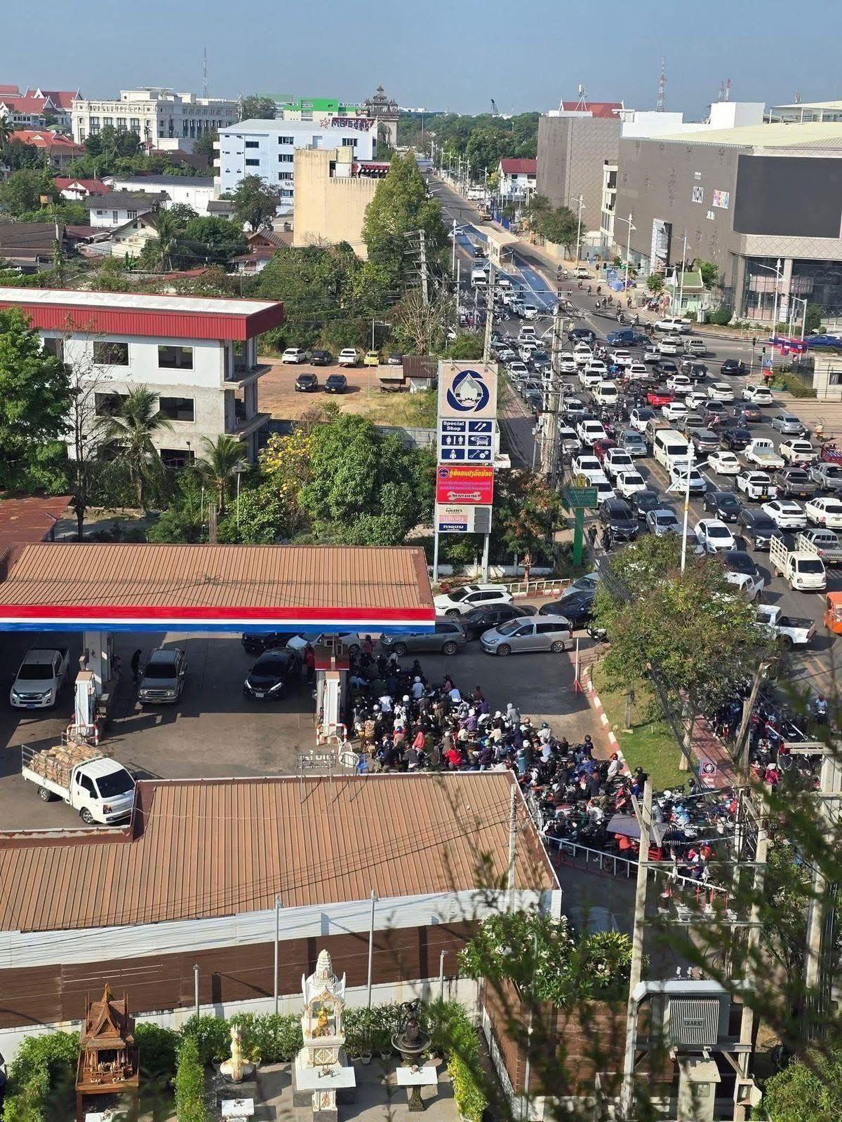 老挝的加油站排队的人太多了，已经排了好几个小时的队想给他们的摩托车加油，但还是没