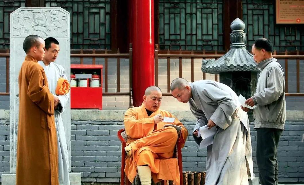 2005年，少林寺的一名僧人向方丈释永信汇报工作。释永信坐在圈椅上，翘着腿，认真