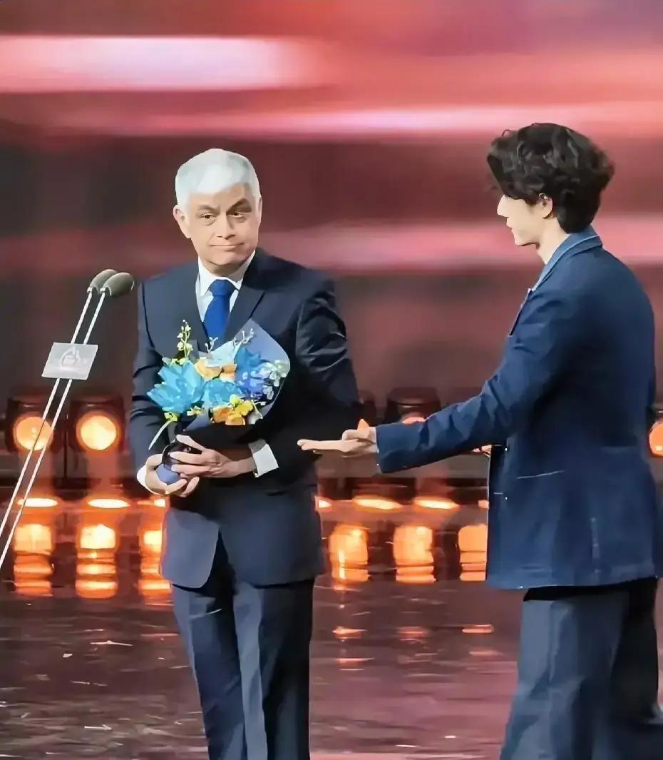 王一博刚领完年度热度人物，没急着走，站在台边瞄到华纳魏总拿着中文稿卡壳。他两