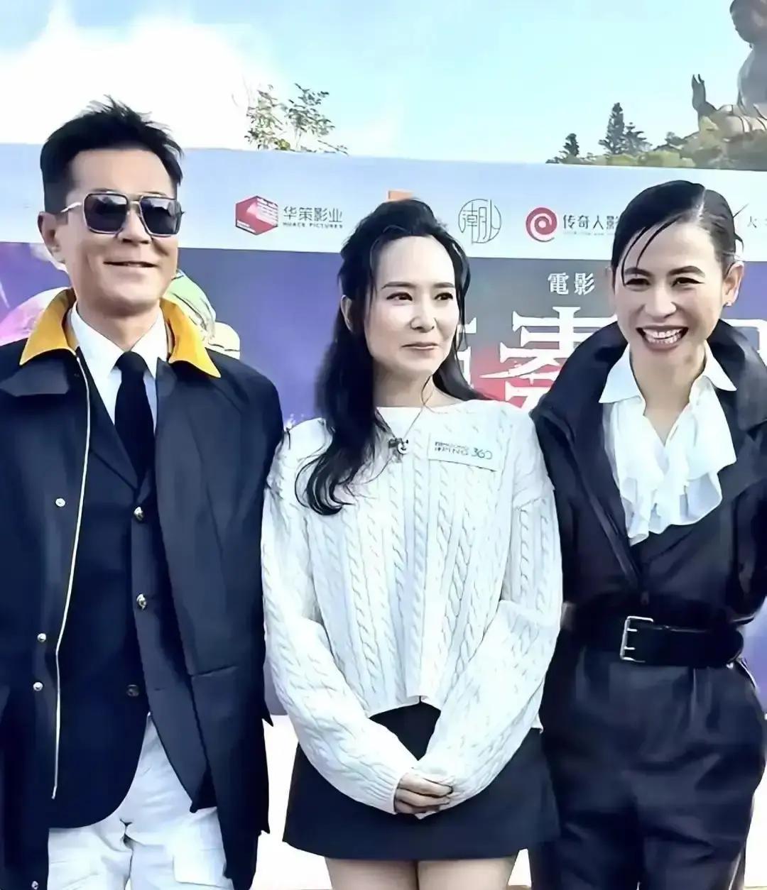 后台闪光灯炸成一片。宣萱大笑挥手，滕丽名侧身贴过去。郭羡妮却往后缩了一下肩膀。