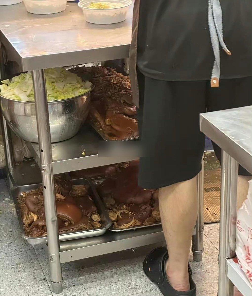 大名鼎鼎的猪脚饭，猪脚被放在厨房里齐脚踝高的低矮金属推车架上，旁边还有穿着短裤和