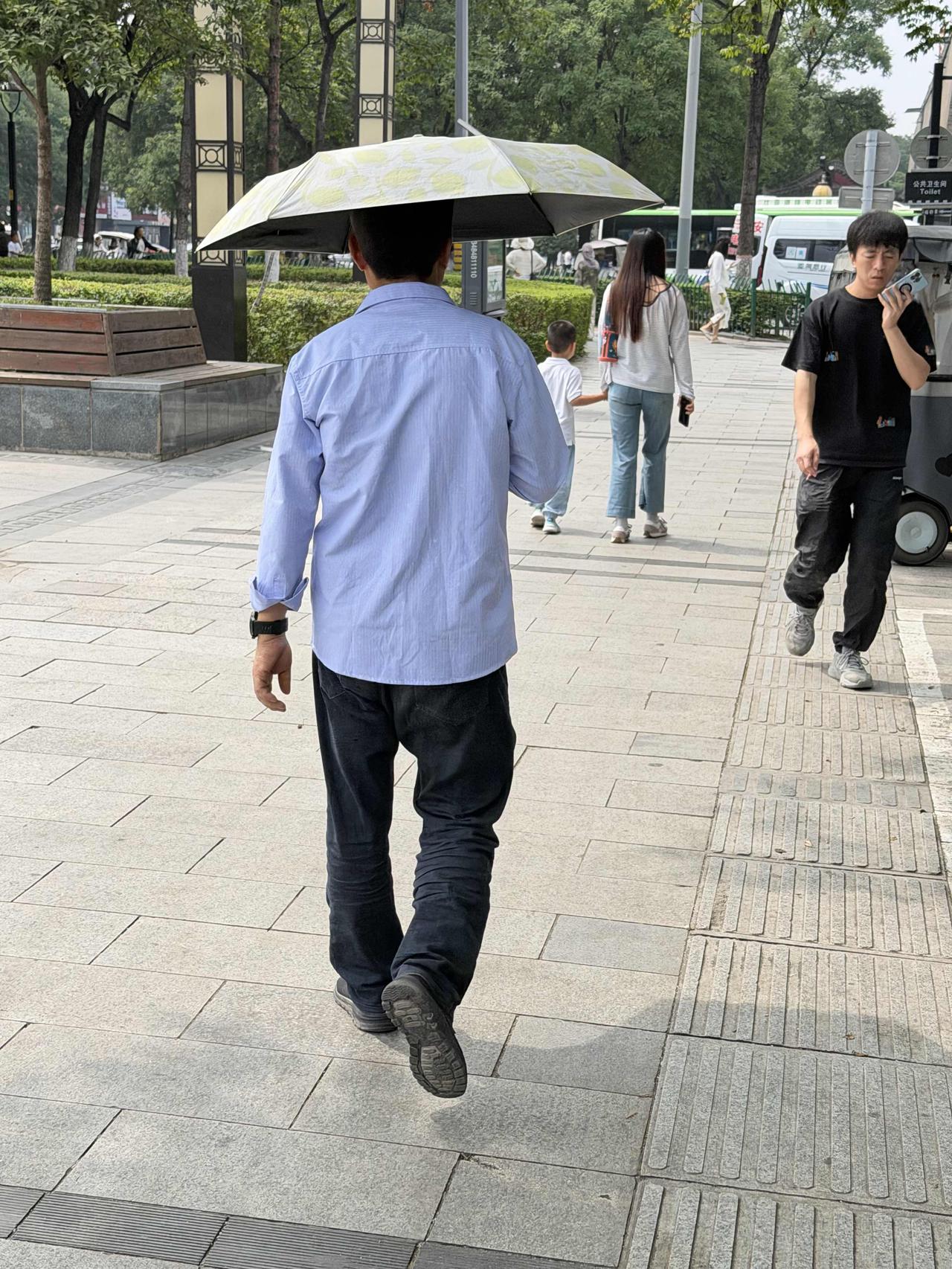 前天上午，我经过西安北马道巷时，看到一位男士，打着遮阳伞，向安定门外走去。有两