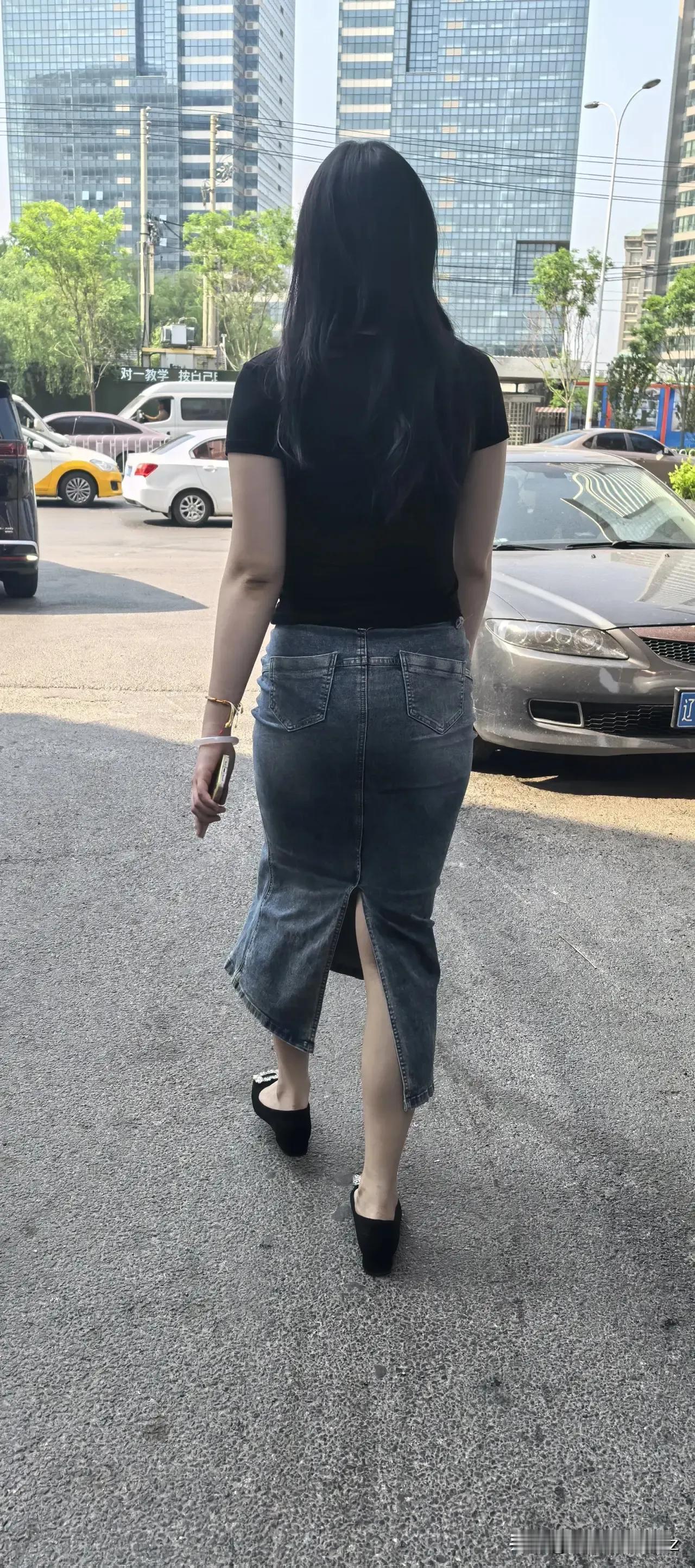 街拍一个穿黑色T恤和牛仔裙的女士在街上走。快乐街拍分享你有哪些得意的街拍街拍