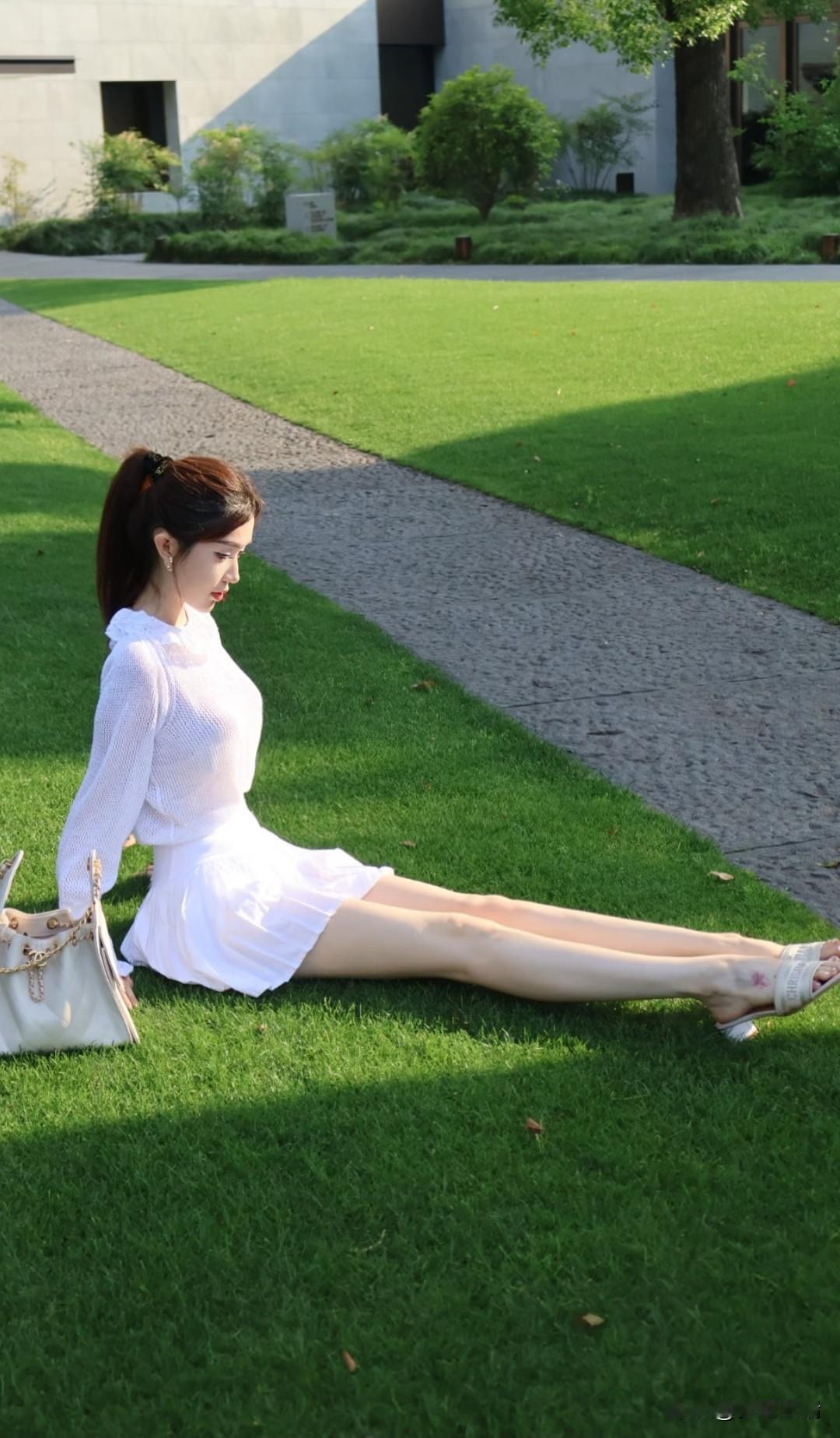 绿草如茵映白裙，轻风拂面意自闲。