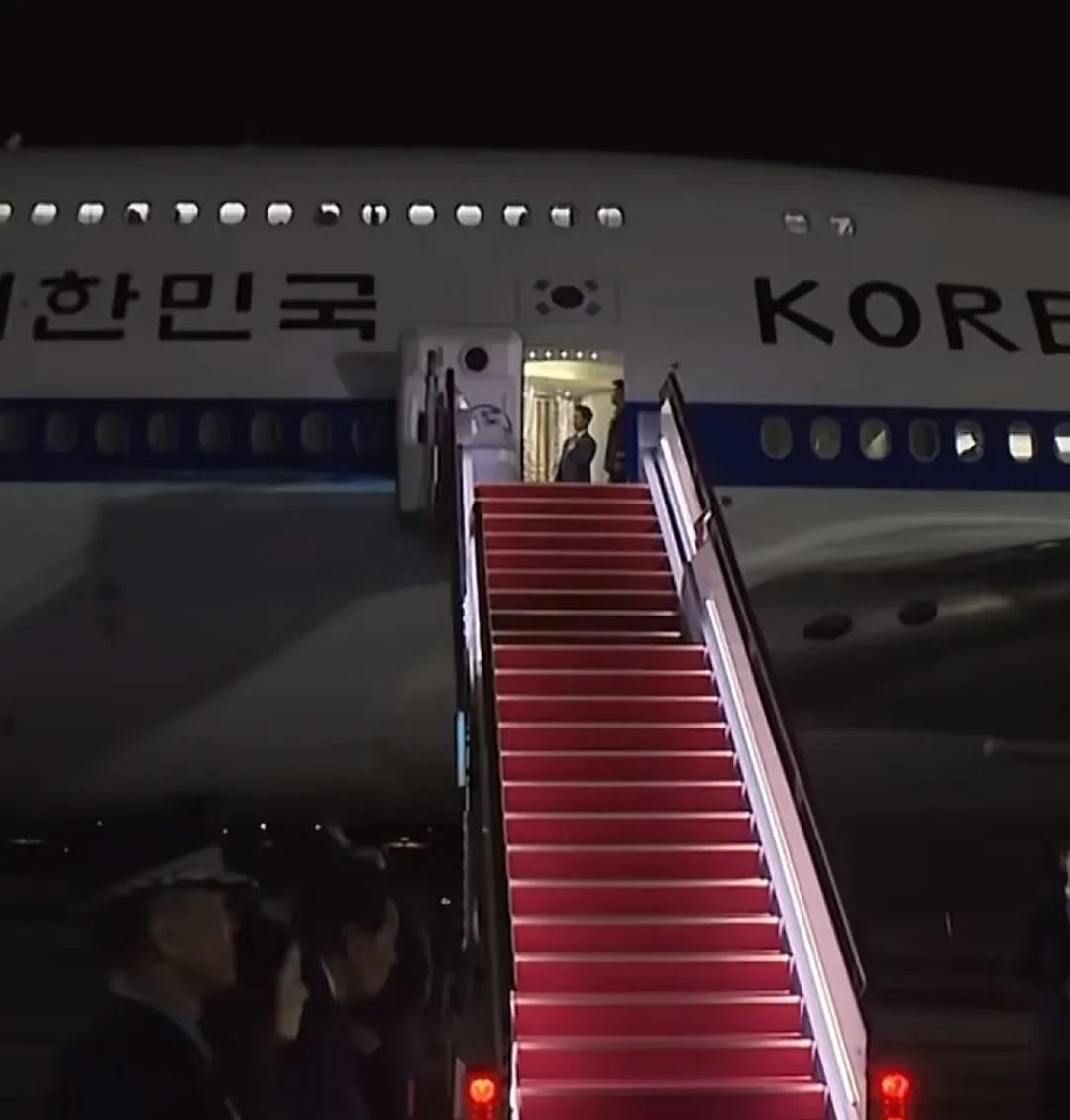 李在明夫妇结束G7峰会后乘坐专机回到韩国。发现一个细节，李在明跟门口的人致谢后