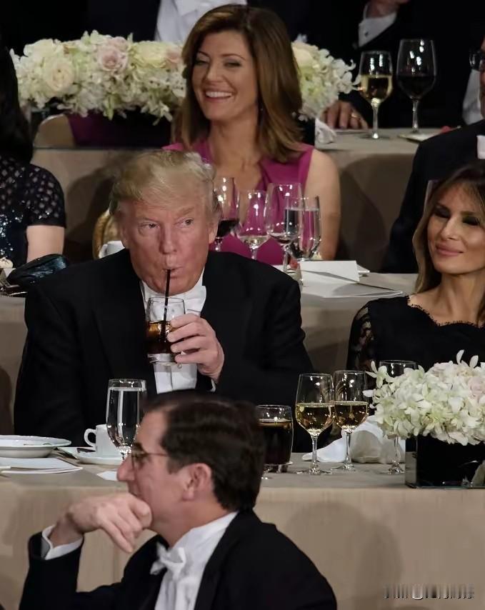 特朗普喝饮料，表情有点怪怪的，嘴里虽然在喝着饮料，可是眼睛好像在看着什么，虽然他