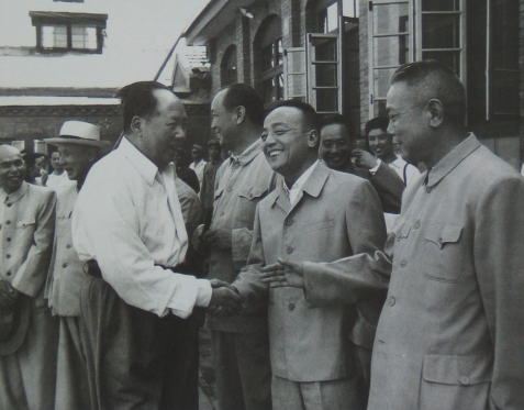 毛主席正和一人握手，旁边一人伸出手来准备和毛主席握手，他们两位后来都担任了国家主