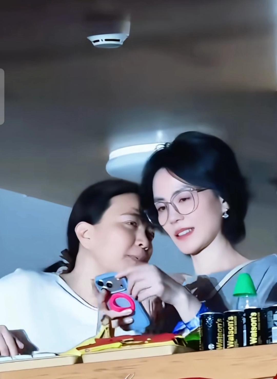 高清镜头下的王菲皮肤白皙，戴着眼镜，看着手机！没有刻意化妆打扮，穿着很随意，身边