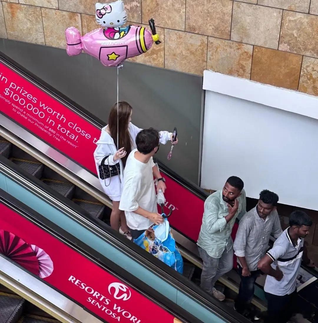 38岁王思聪和女友懒懒在新加坡过年，两个人一起到商场购物，他帮女友提着购物袋，看