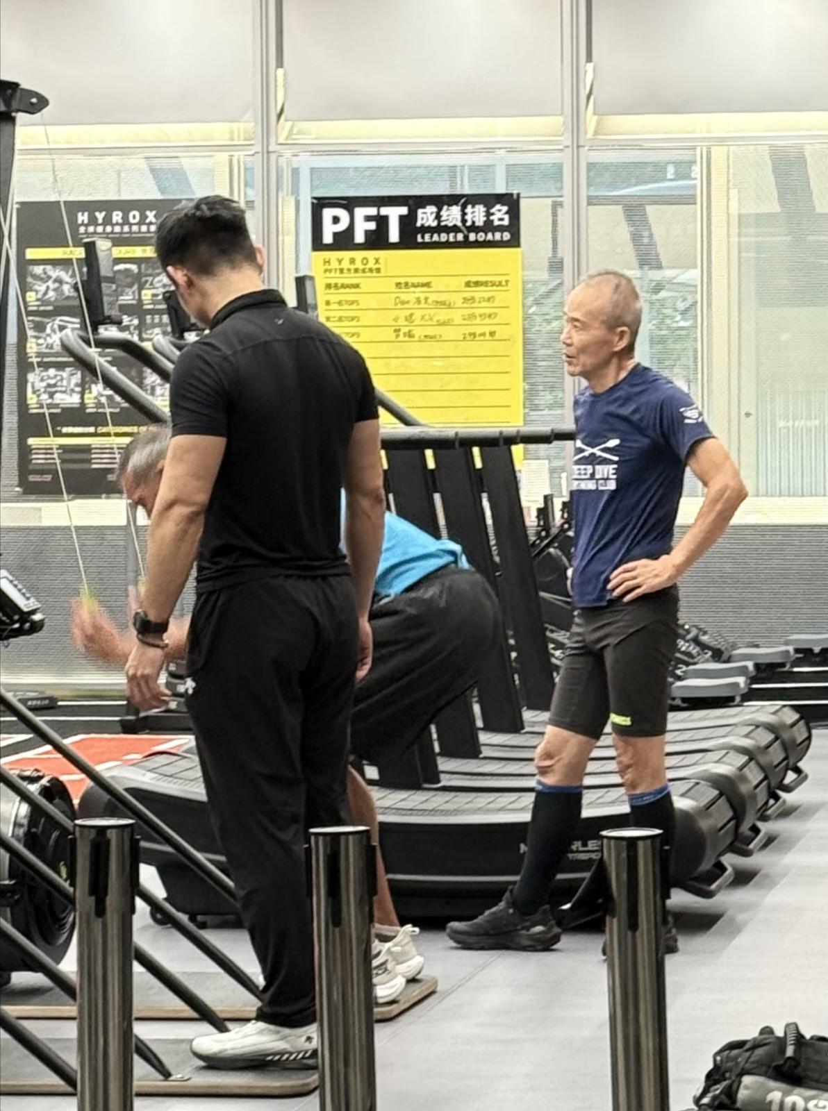 75岁王石在健身房锻炼身体被偶遇，他穿着一身运动服，在一名男教练的指导下做臂力训