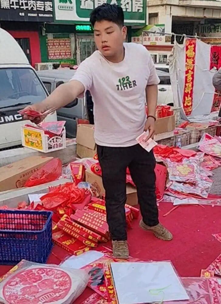 山东招远，一14岁男孩在街上摆摊卖起了春联，一女子看到后觉得有些吃惊，于是便询问