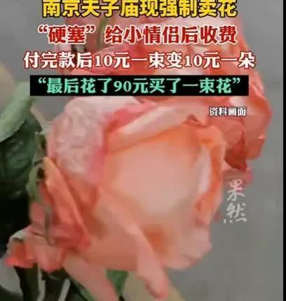 江苏南京，男子和女友去游玩，被卖花的女子拦下，她往男子女友的怀里塞一束鲜花，男子