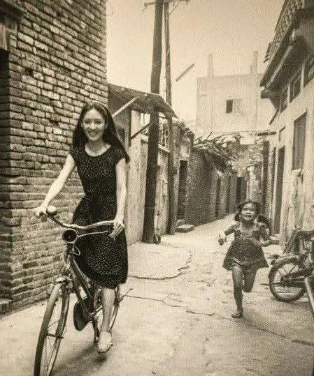 1980年，胡因梦拍摄电影间隙骑着自行车在巷道中悠闲的穿行！胡茵梦不愧