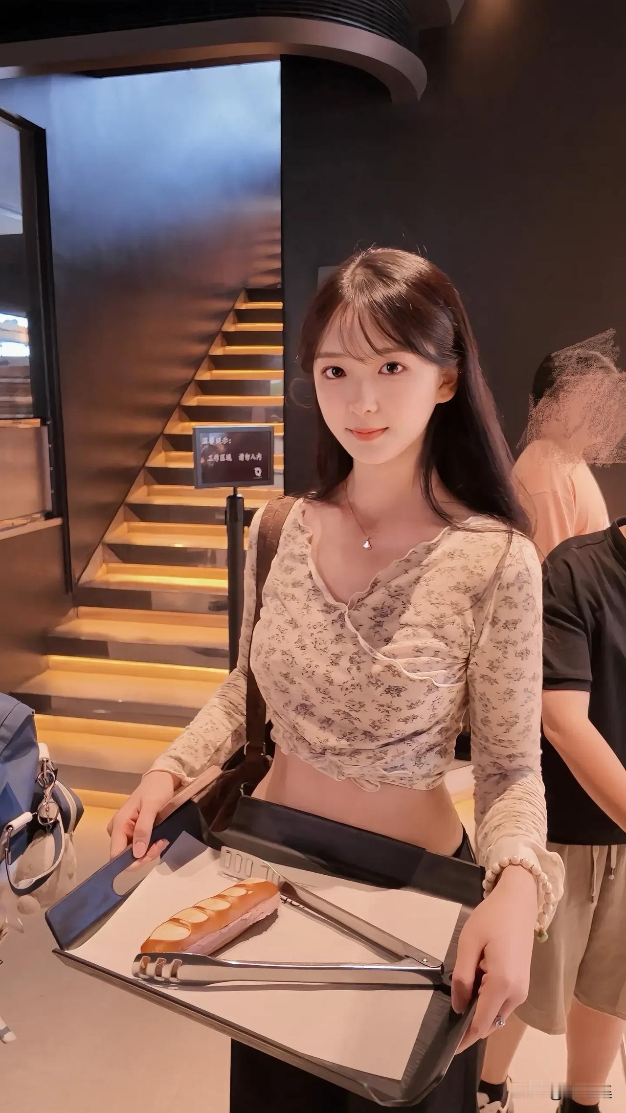 女生在店里拿蛋糕准备上楼。