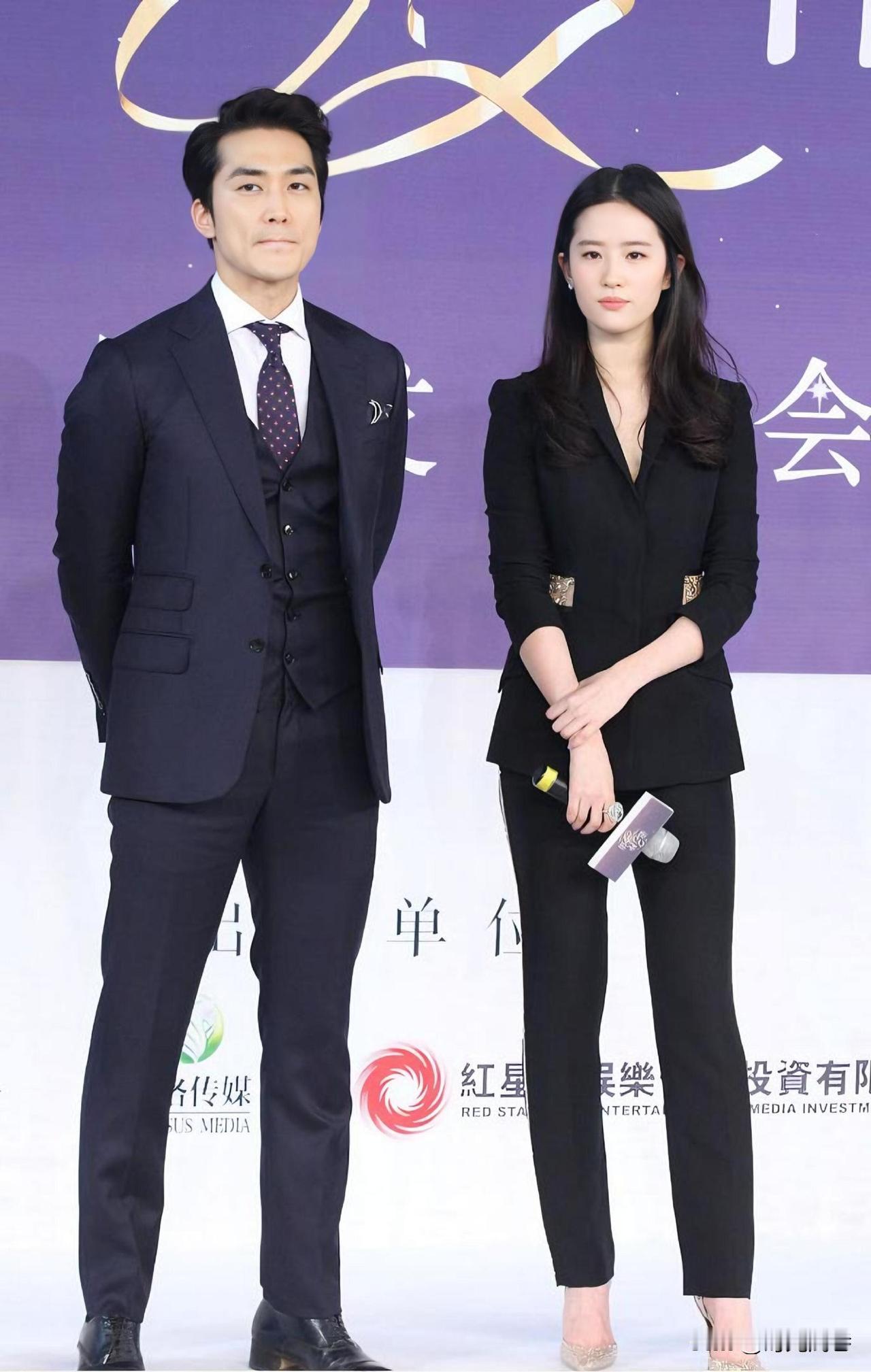 刘亦菲黑色西服套装穿搭，又美又飒。和身旁的男士站在一起，这才是真正的郎才女貌！明