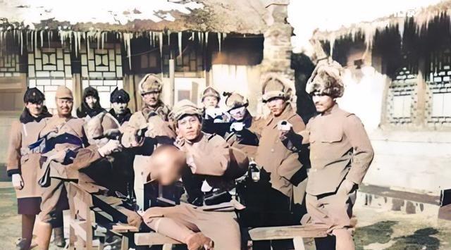 一群日寇围在餐桌前举行庆功宴，最前面手里提着一颗血淋淋的人头。直到82年后，我们