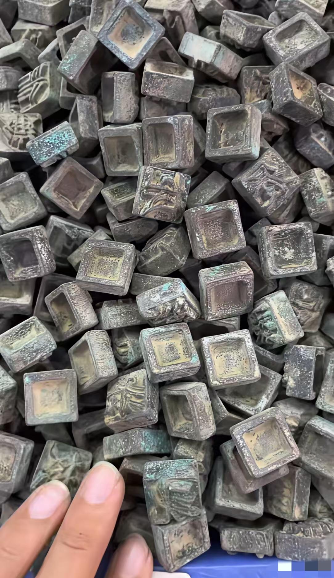 在一位老人家里发现了很多四四方方的小铜块铜块背面都刻有字，字体不认识，据老人讲