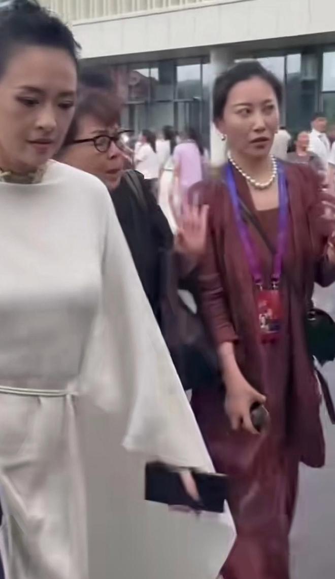 章子怡参加电影盛典，身着白礼服闪耀全场。助理殷旭（章子怡亲嫂子）以红色衣着引人注